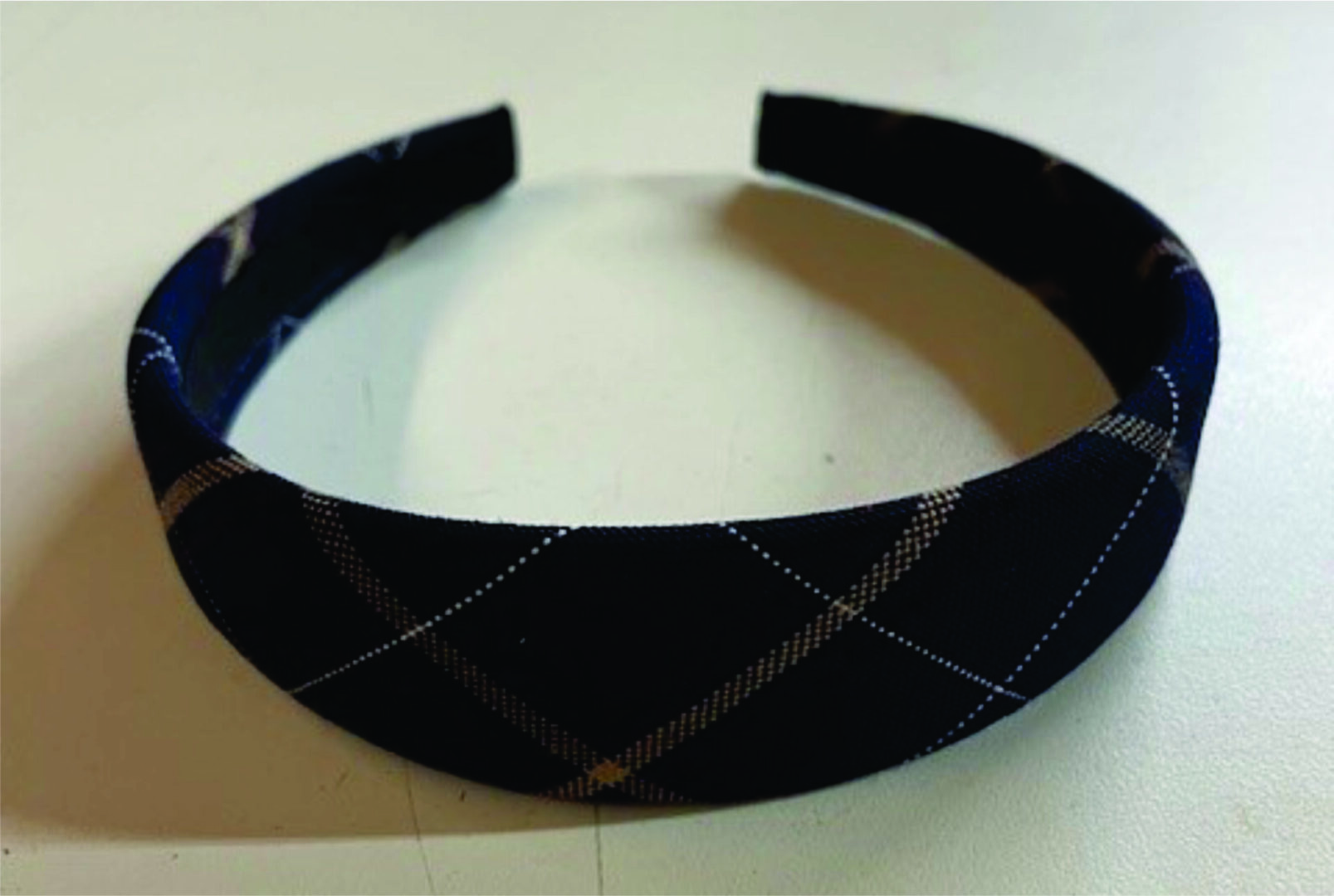 Black headband with diamond pattern design.