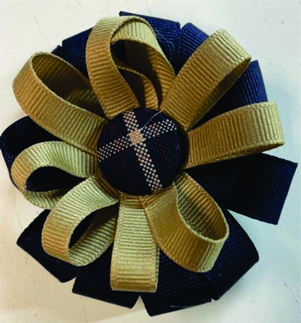 Ribbon flower brooch in navy and gold.