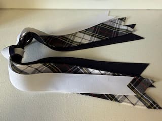 Assorted ribbons in black and plaid patterns.