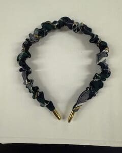 Ruffled fabric headband with gold ends.